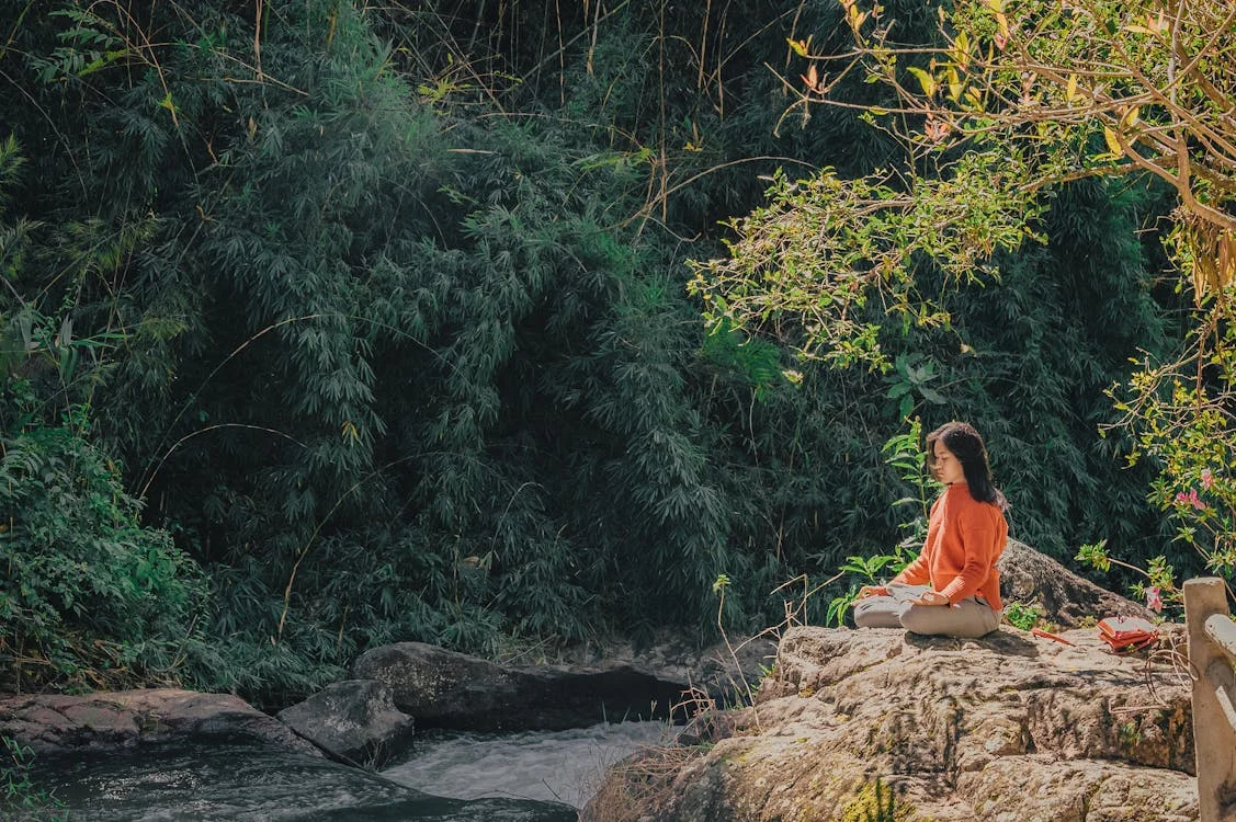 Persona meditando en plena naturaleza, conectando con sus registros akashicos.